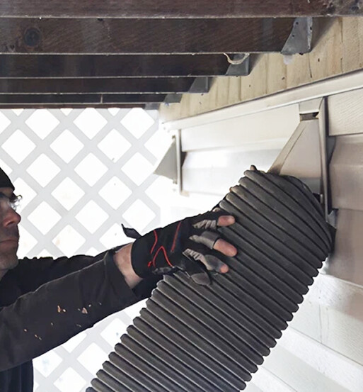 Close-up of technician's hand holding flexible dryer vent hose during installation or maintenance